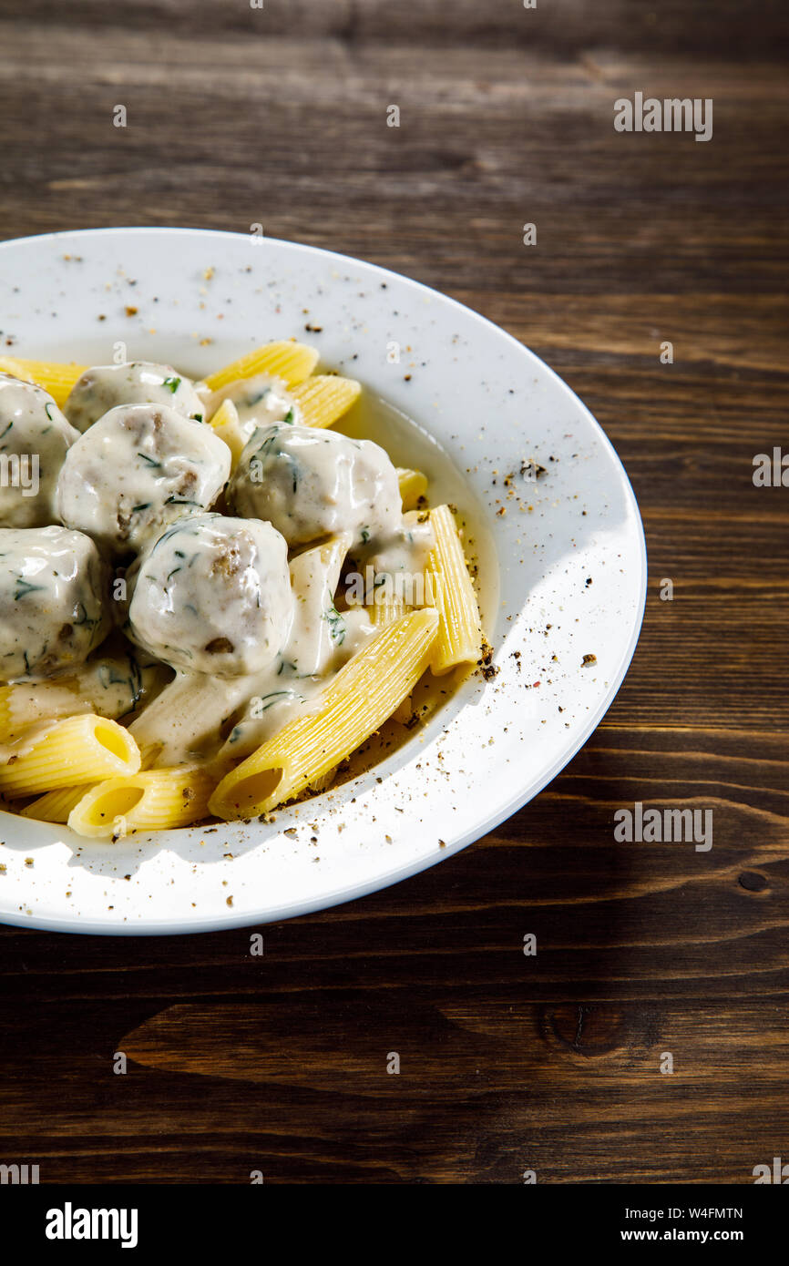Meatballs with pasta and sauce on wooden table Stock Photo