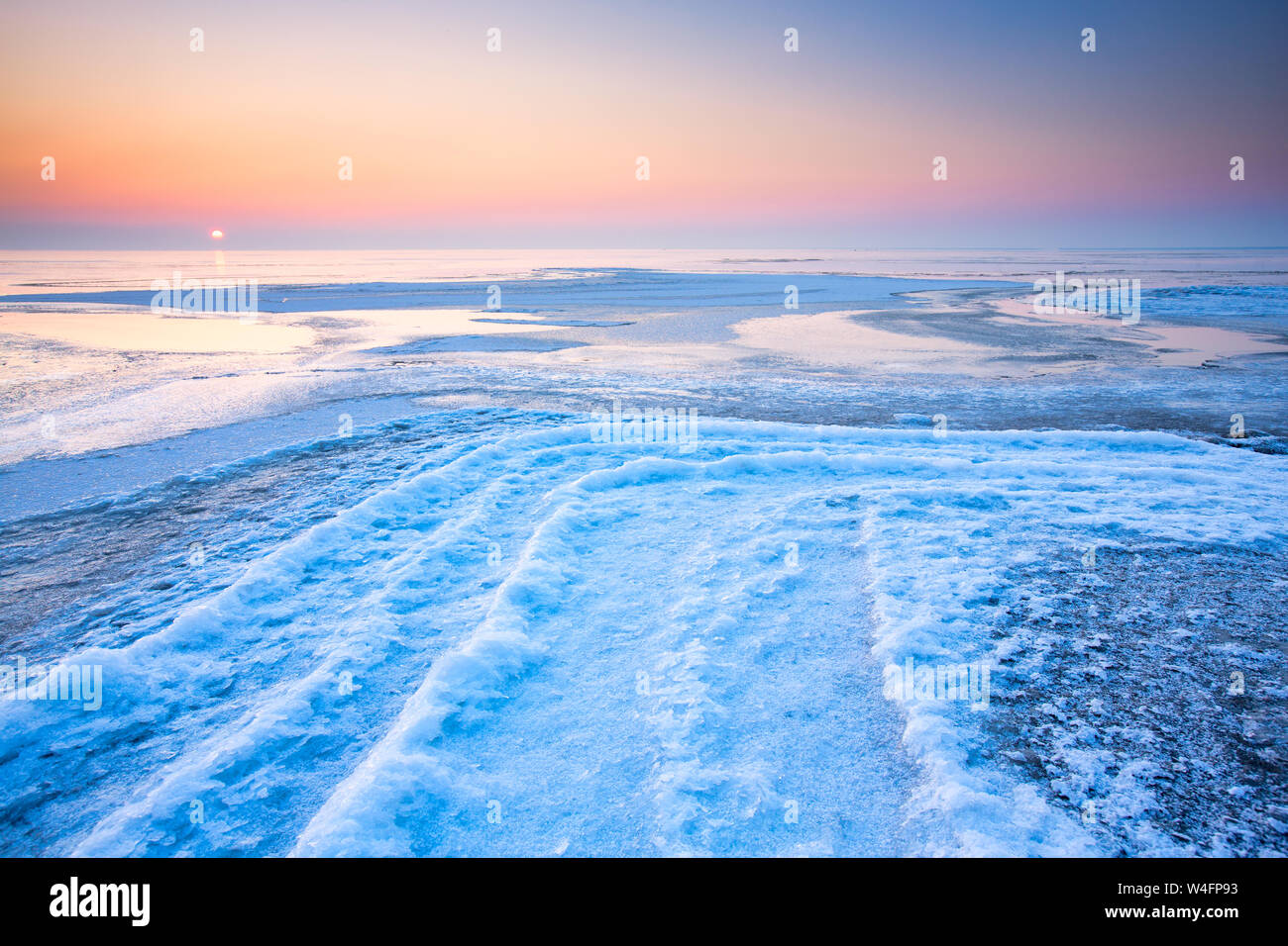 A polar landscape in winter with ice and snow and a colourful landscape with a blue and pink sky Stock Photo
