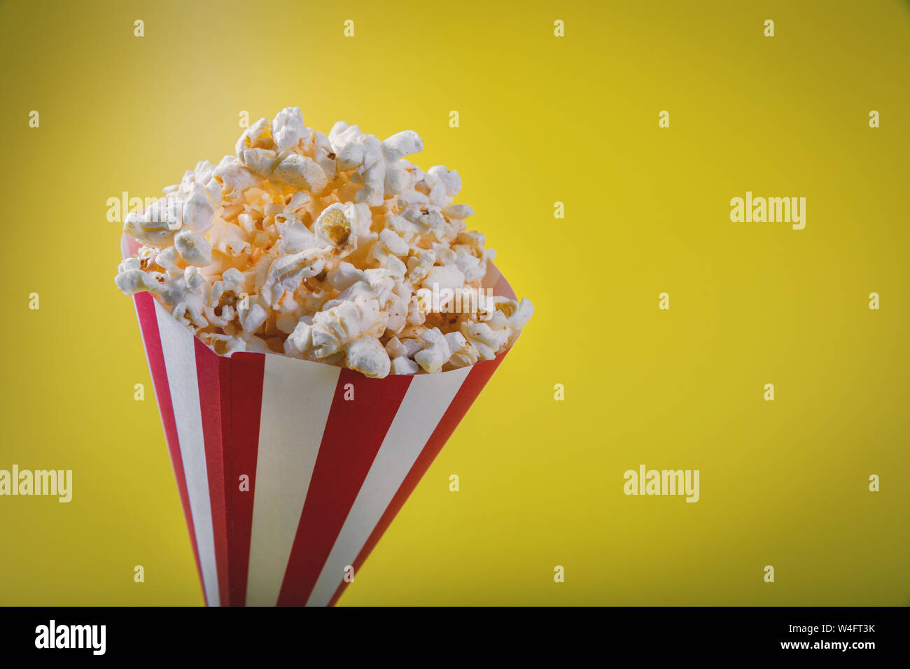 striped pop corn bag on yellow background with copy space Stock Photo