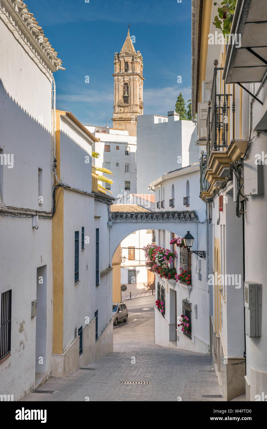 Cuesta de San Juan, alleyway with buttress between buildings, Iglesia de la Asuncion in distance, in Cabra, Cordoba Province, Andalusia, Spain Stock Photo