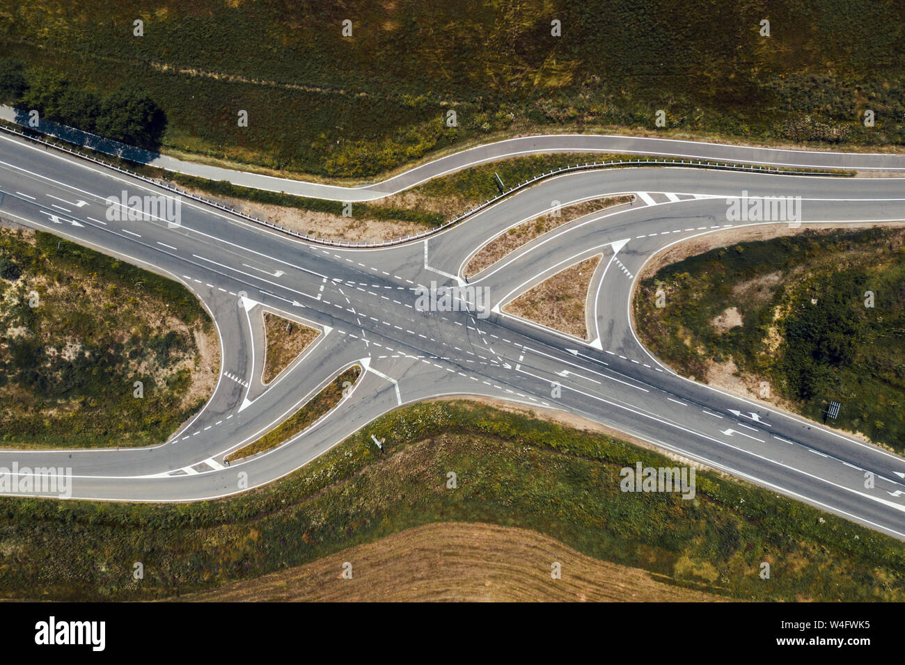 Aerial view of empty road intersection with turning lines from drone
