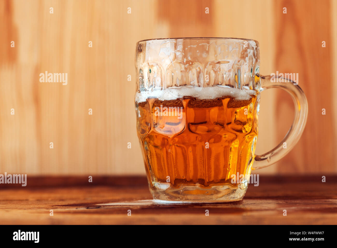 Beer jug on bar counter, single drinking glass with fresh alcohol beverage Stock Photo