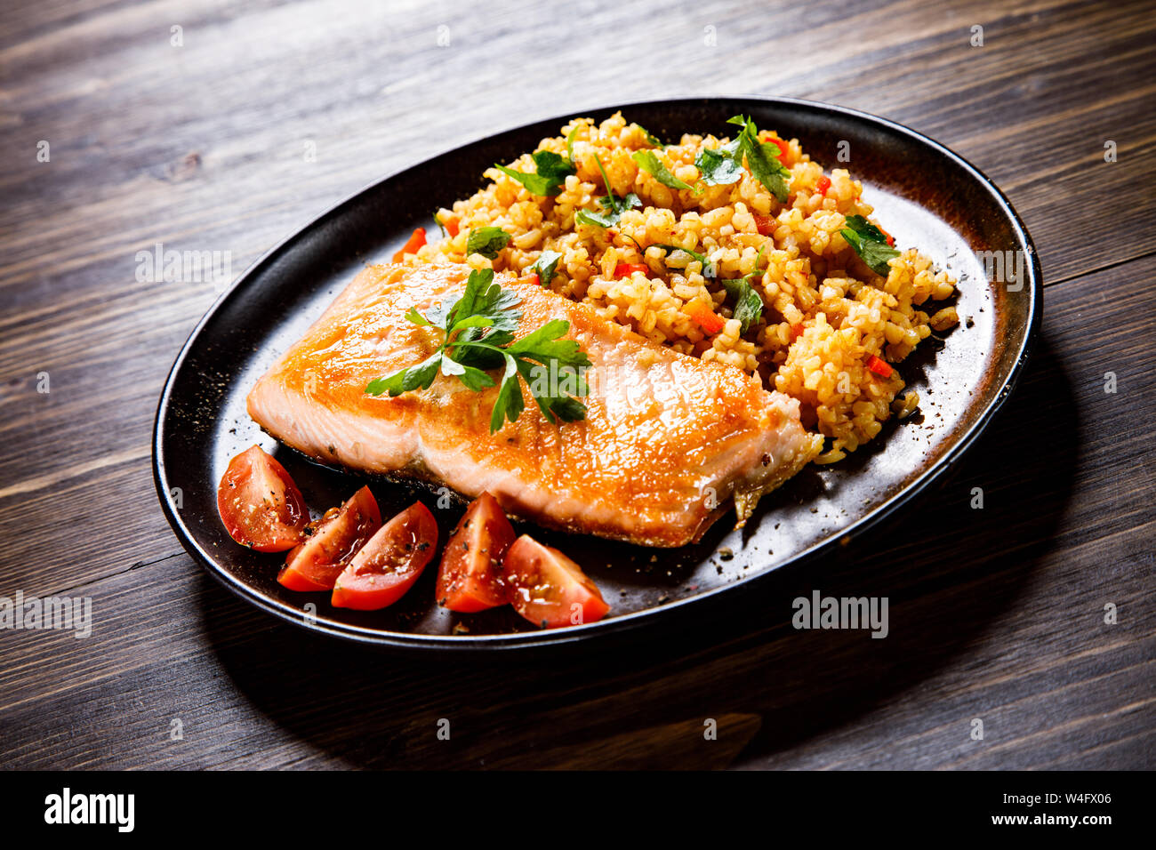 Roast salmon with groats and vegetables Stock Photo