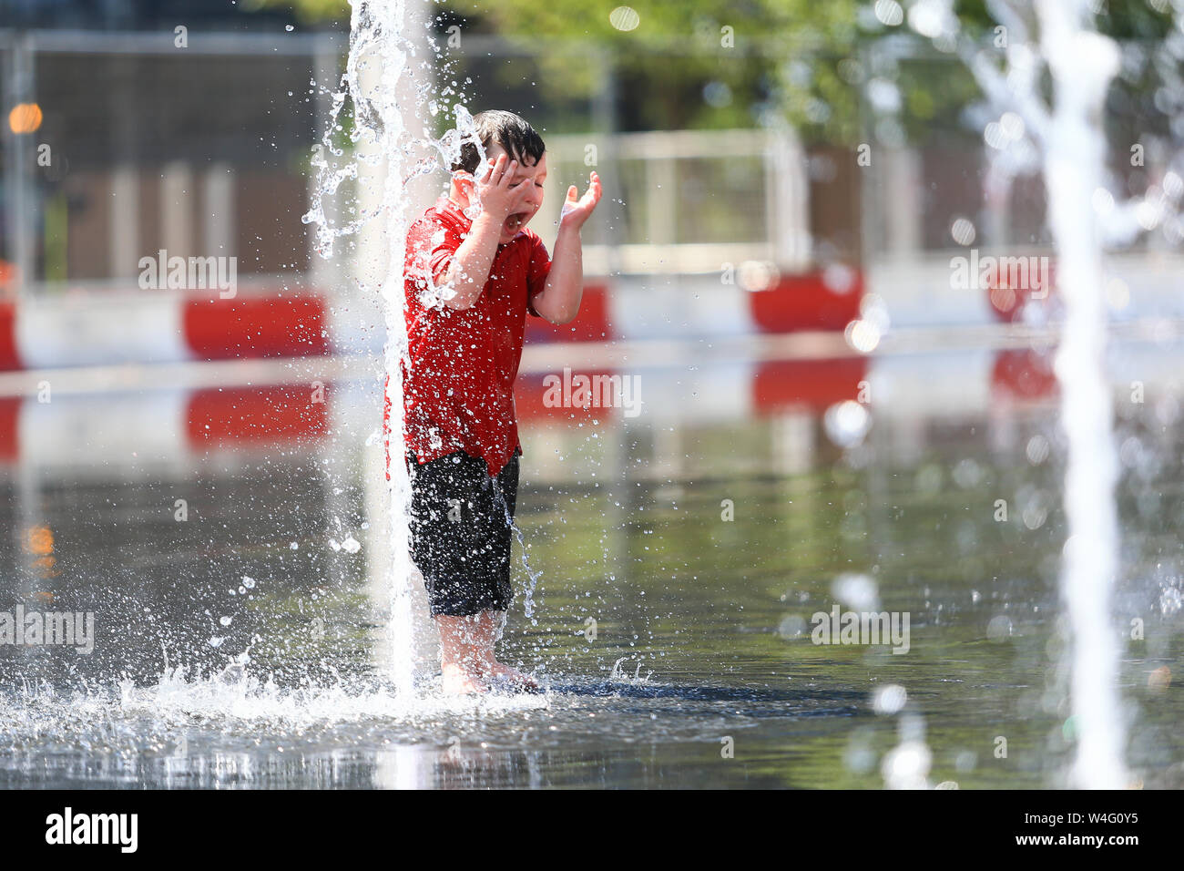 Young boy having fun in city water fountains, Birmingham UK Stock Photo