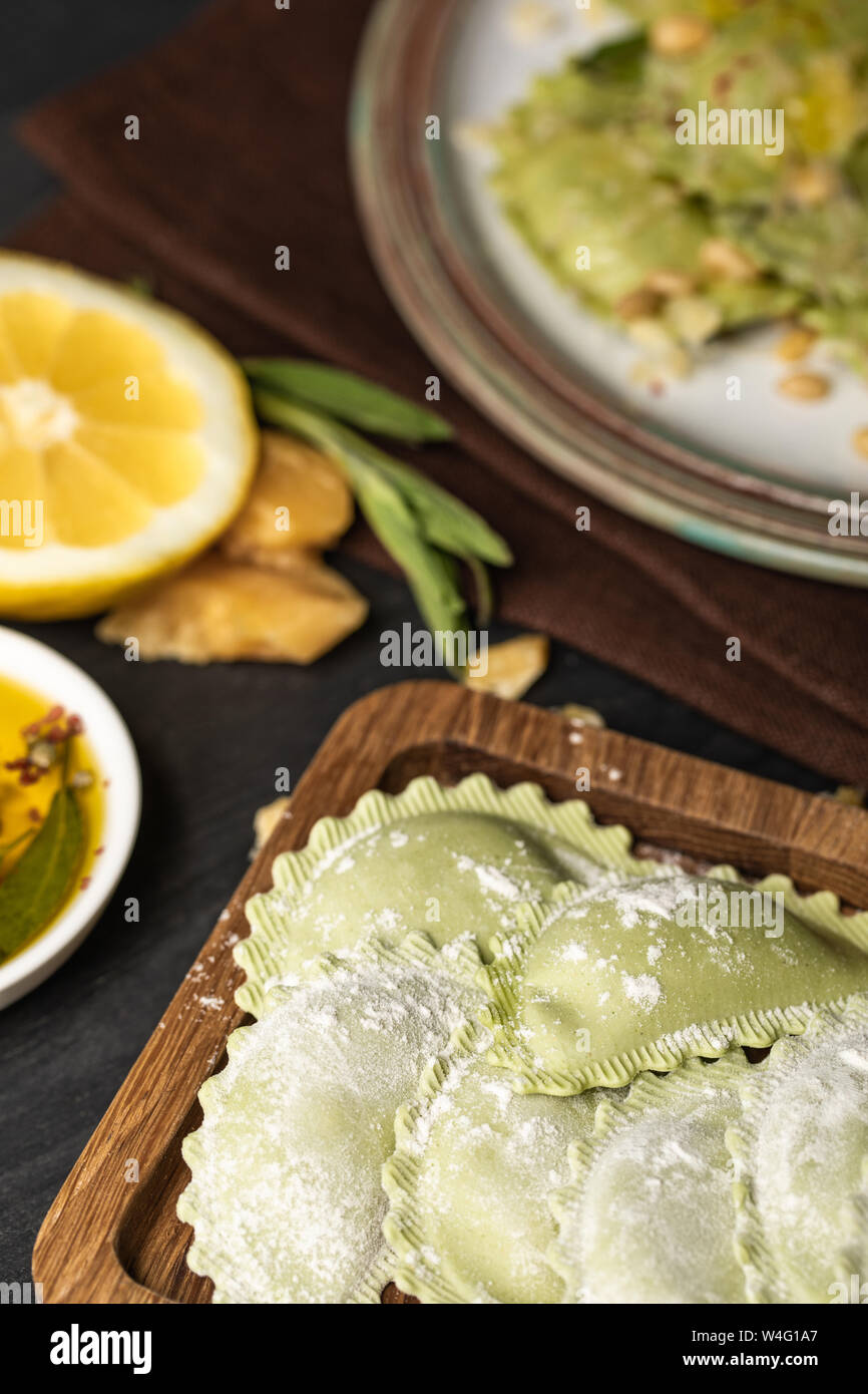 selective focus of green raw ravioli with flour on wooden board Stock ...