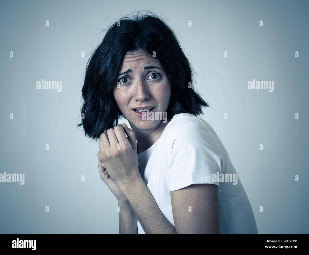 Close up of young woman with frightened eyes, shocked, cowered ...