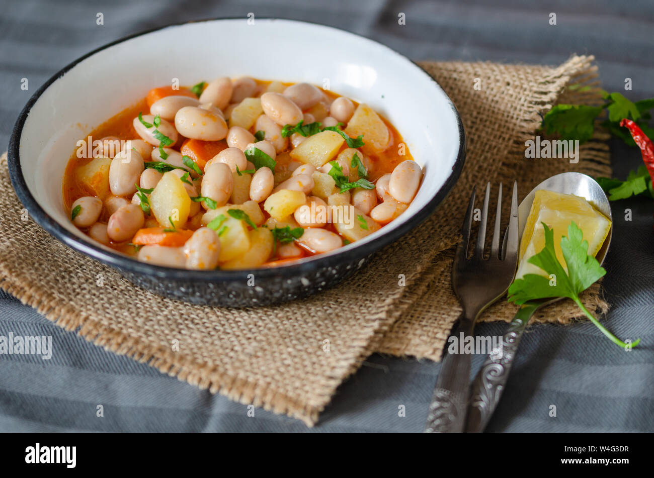 Kidney beans in tomato sauce with carrot in a white bowl, closeup