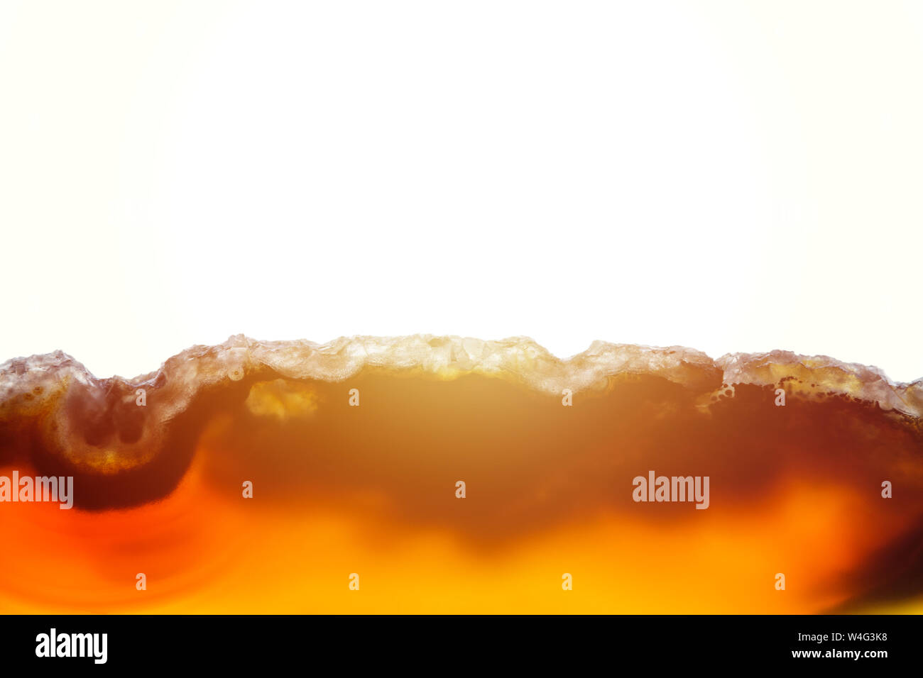 Abstract background, brown and orange agate slice mineral cross section with sunbeam on white background Stock Photo