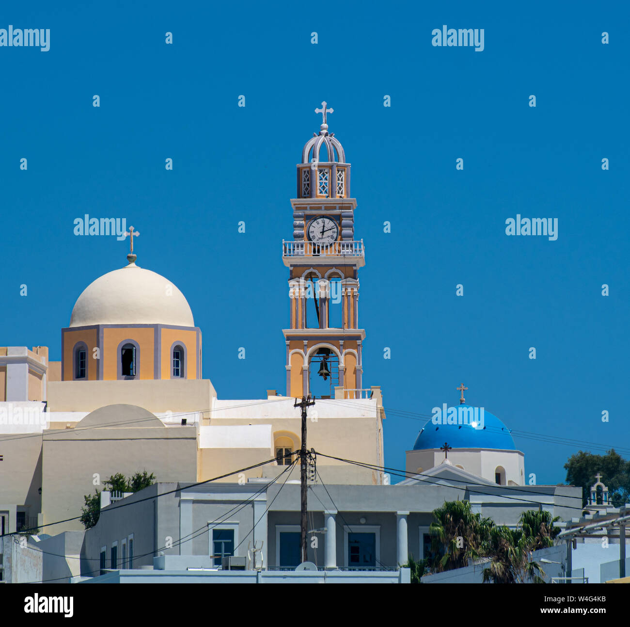 The twin domes and clock tower of St John The Baptist Cathedral in Fira ...