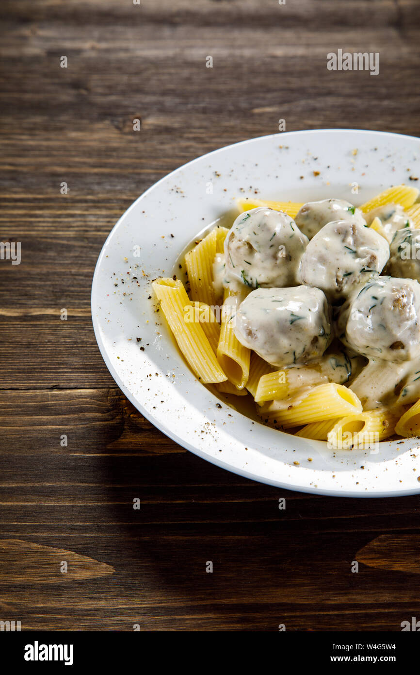 Pasta with meatballs and sauce on wooden table Stock Photo