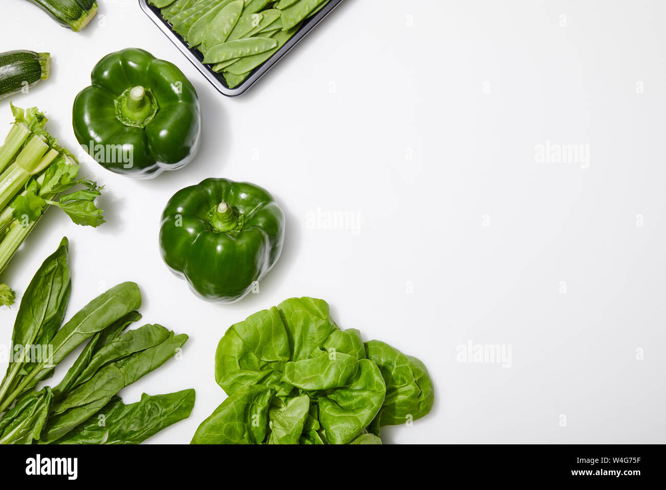 top view of green nutritious vegetables on white background with copy ...