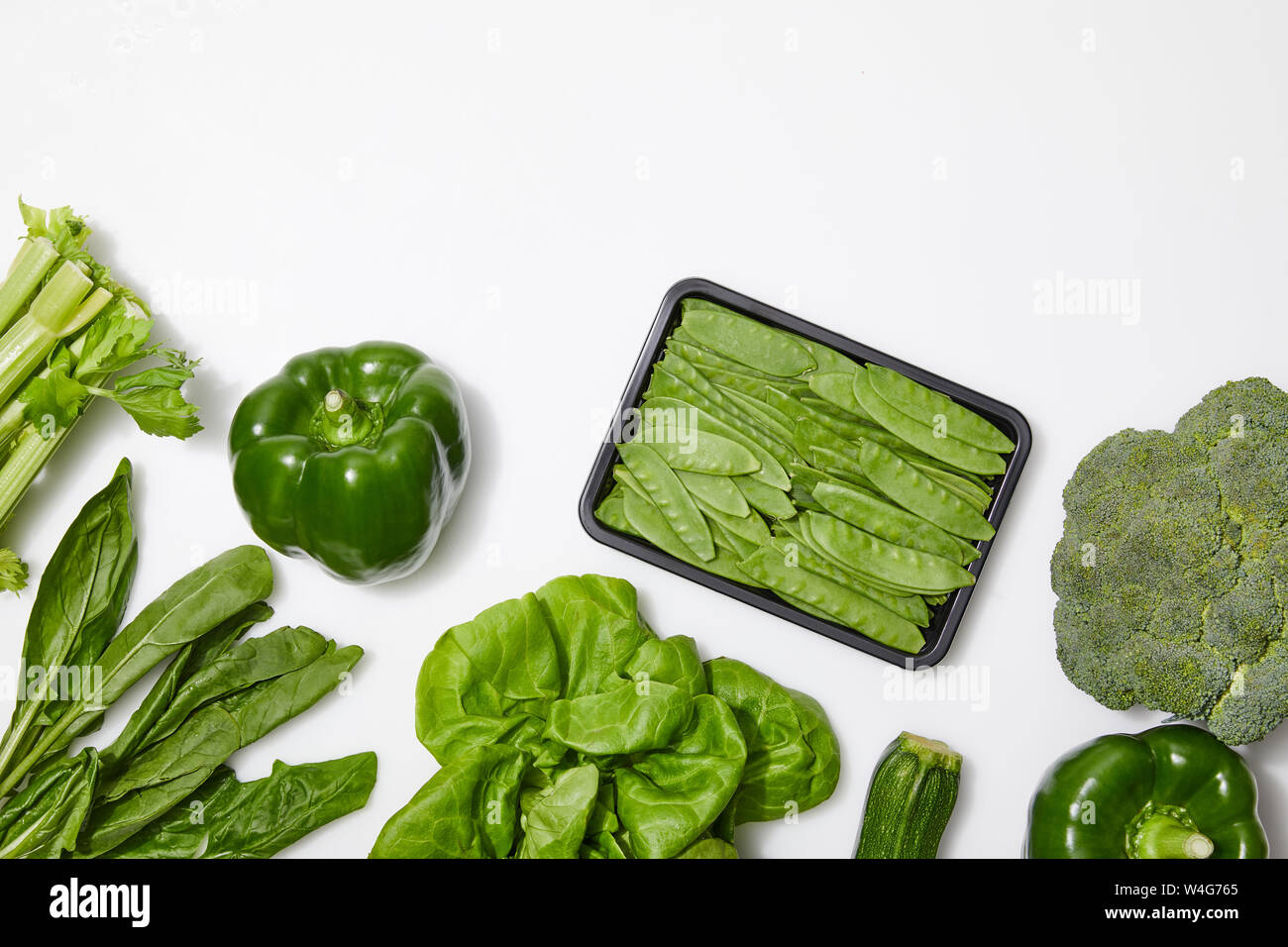 top view of green nutritious vegetables on white background with copy ...