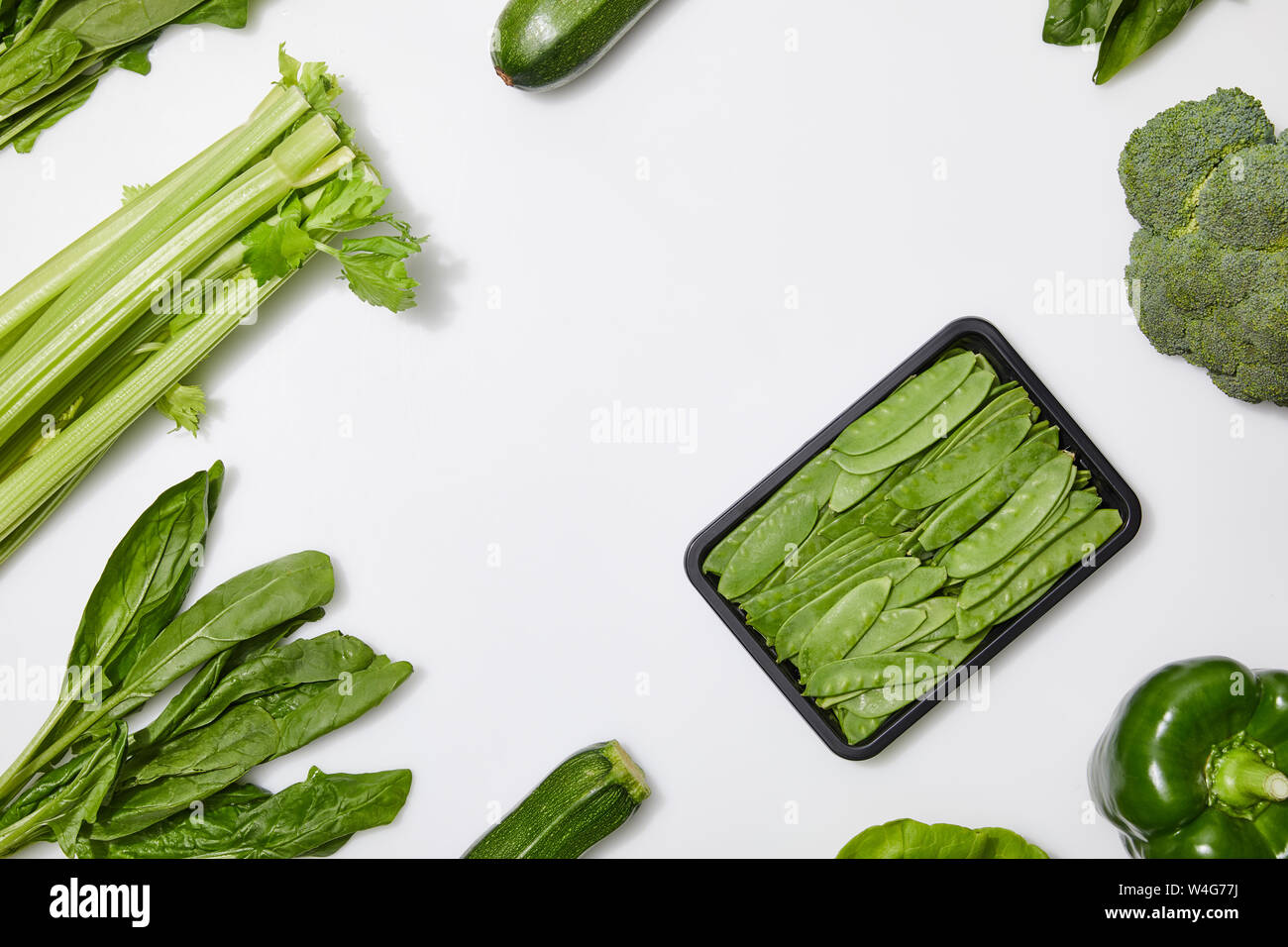 top view of green nutritious vegetables on white background with copy ...