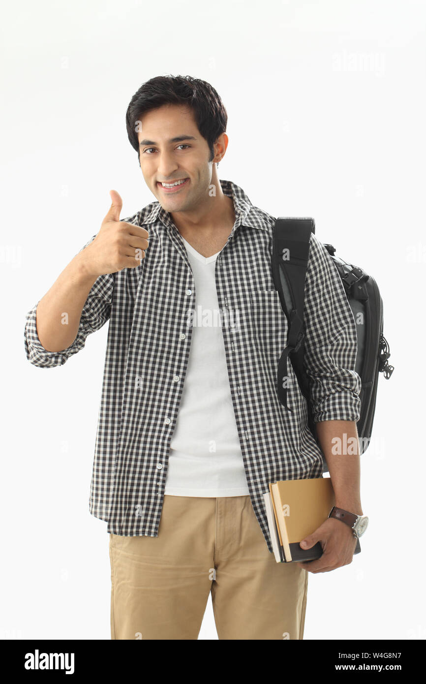 College student smiling and showing thumbs up sign Stock Photo - Alamy