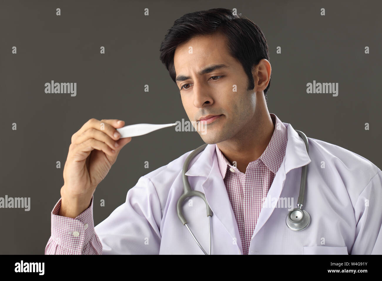 Male doctor checking the temperature on a thermometer Stock Photo Alamy