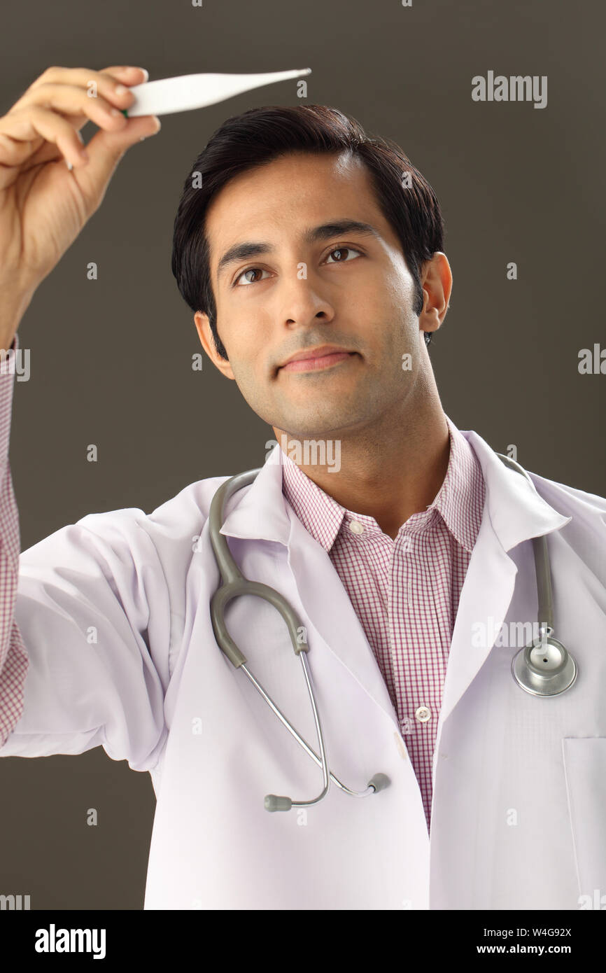 Male doctor checking the temperature on a thermometer Stock Photo Alamy