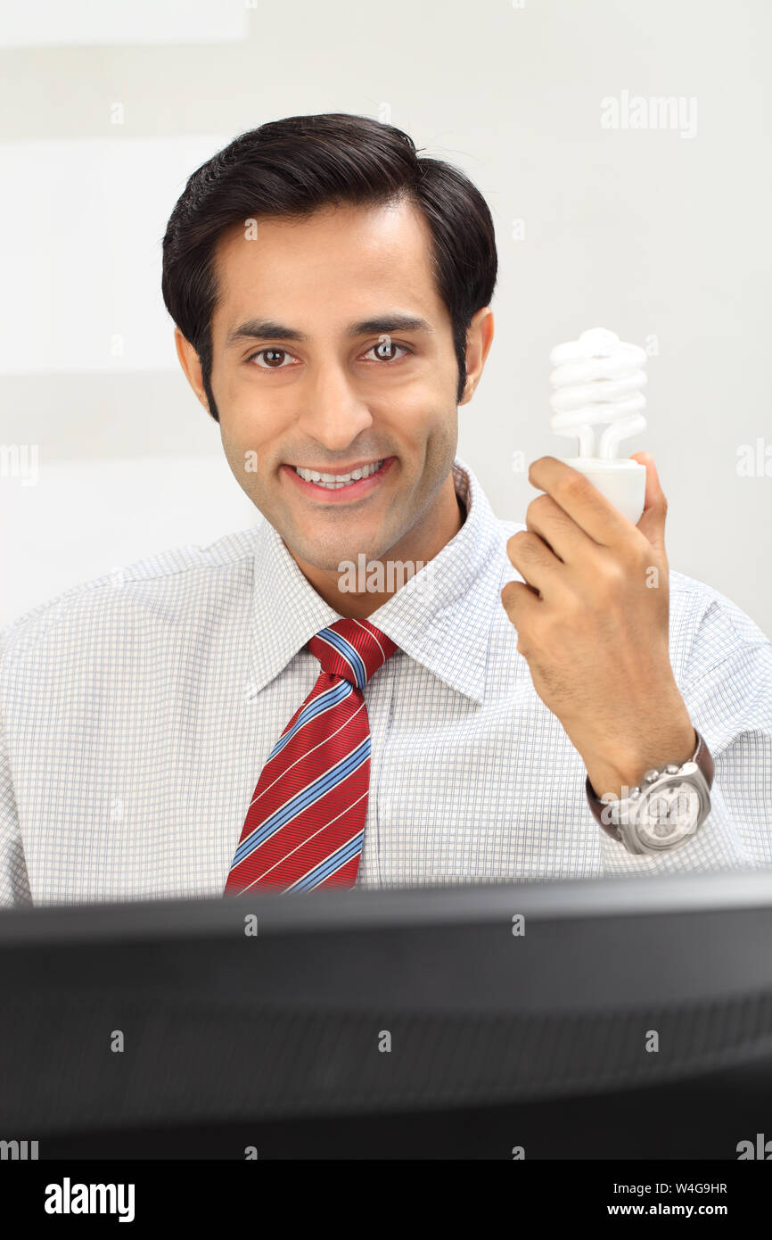 Businessman holding a light bulb Stock Photo - Alamy