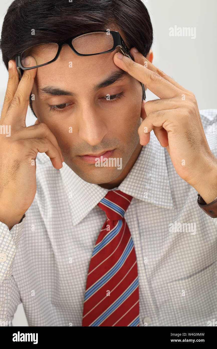 Indian businessman suffering from headache Stock Photo - Alamy