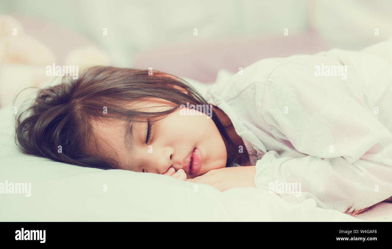 Sweet little girl is sleeping in bed at home Stock Photo - Alamy