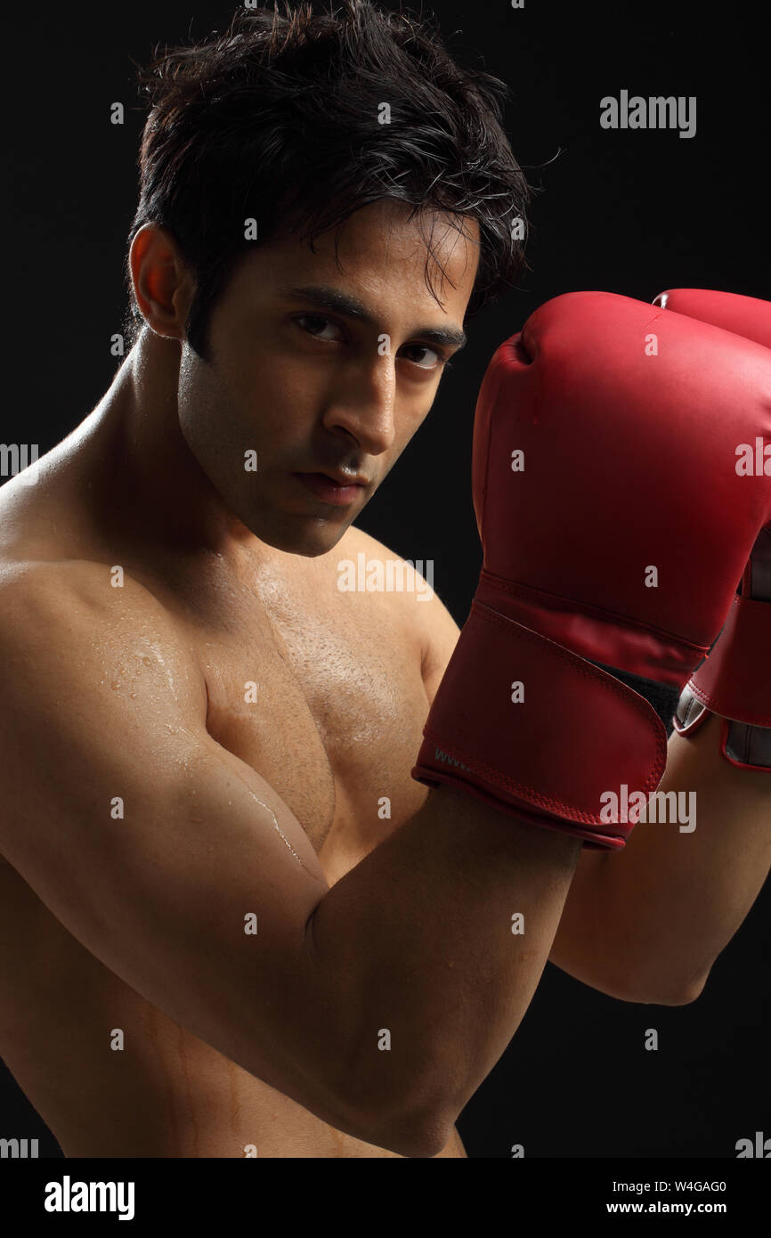 Indian young man wearing boxing gloves Stock Photo Alamy