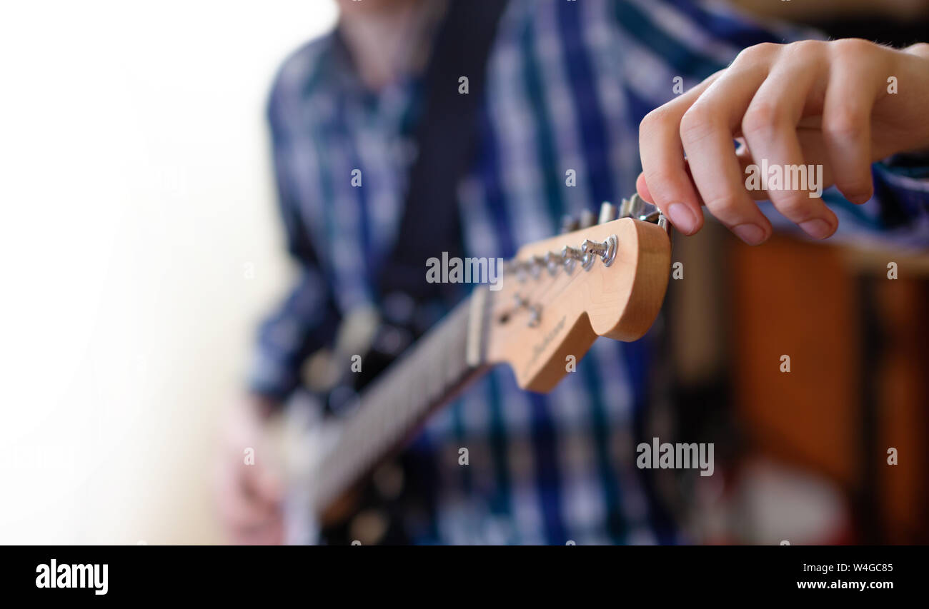 The young man tuning the electric guitar. Closeup Stock Photo Alamy