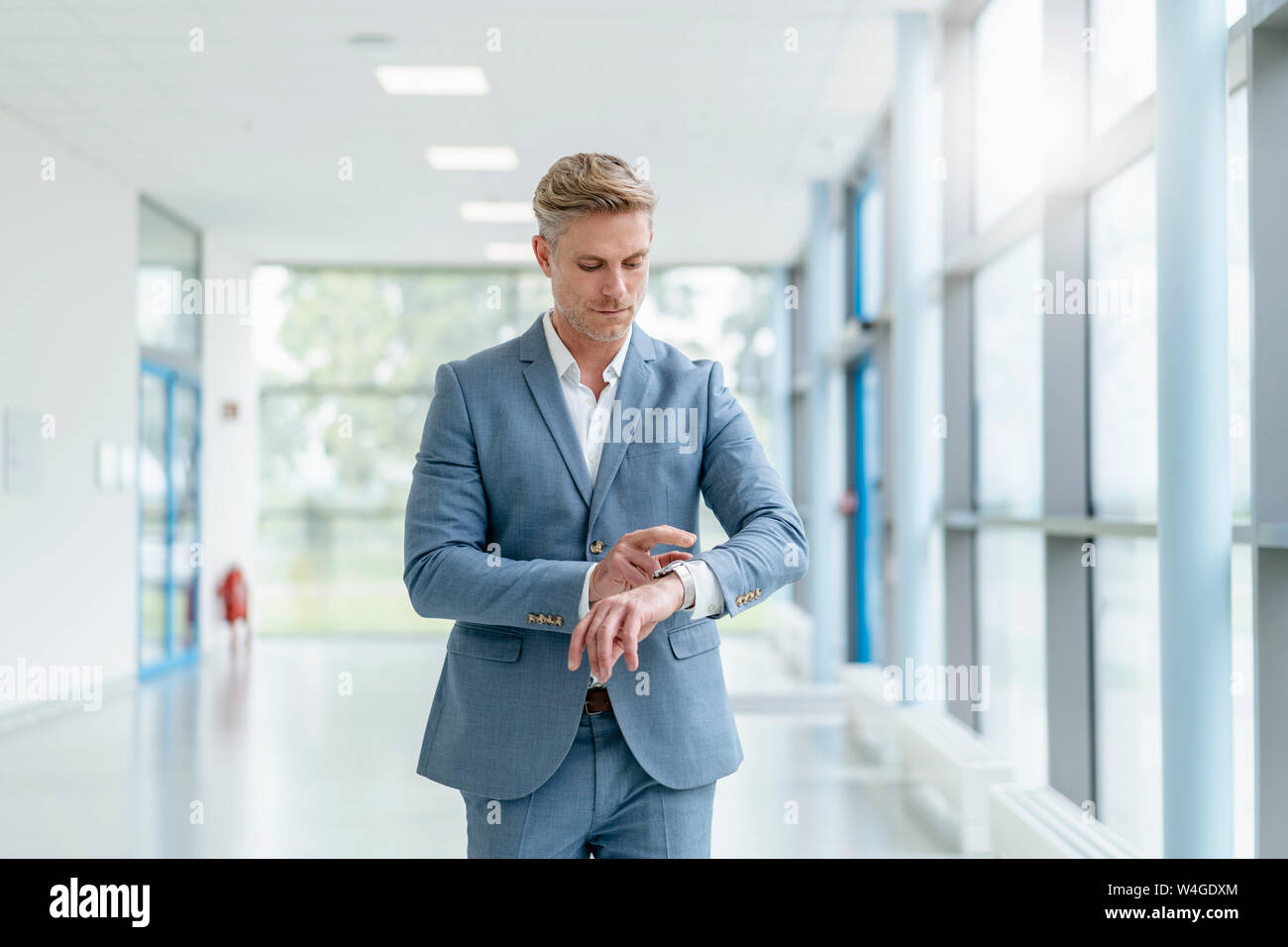 Businessman in a passageway checking the time Stock Photo