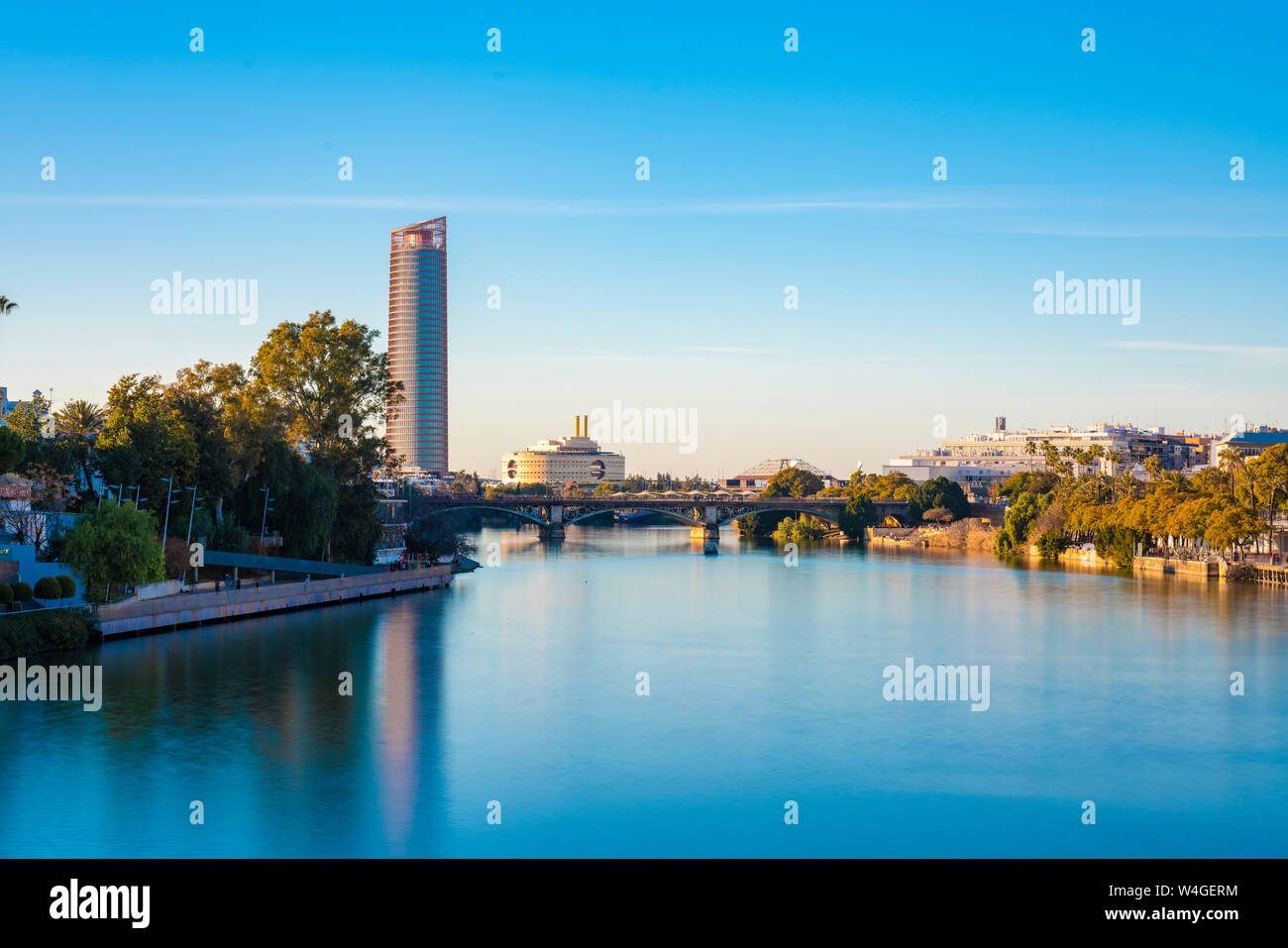 Long exposure of Torre Sevilla and bridge crossing the Canal de Alfonso XIII, Seville, Spain Stock Photo
