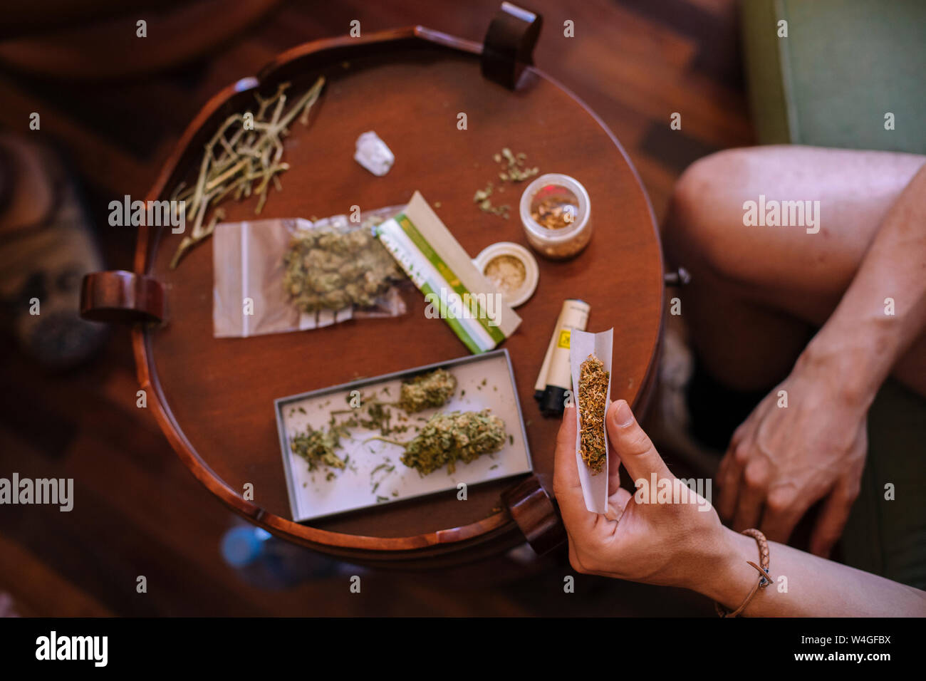 Close-up of a hands rolling a joint of marijuana from above Stock Photo