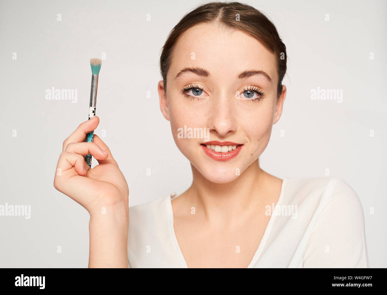 Portrait of smiling young woman with beauty brush Stock Photo