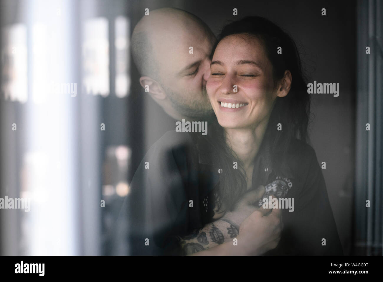 Couple in love behind windowpane Stock Photo