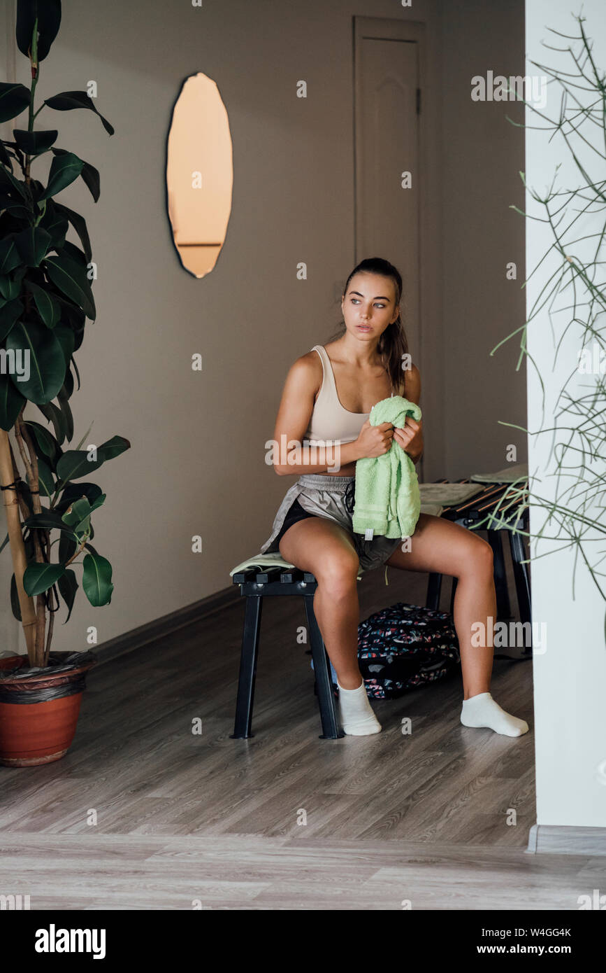 Young woman in locker room finishing workout in gym Stock Photo