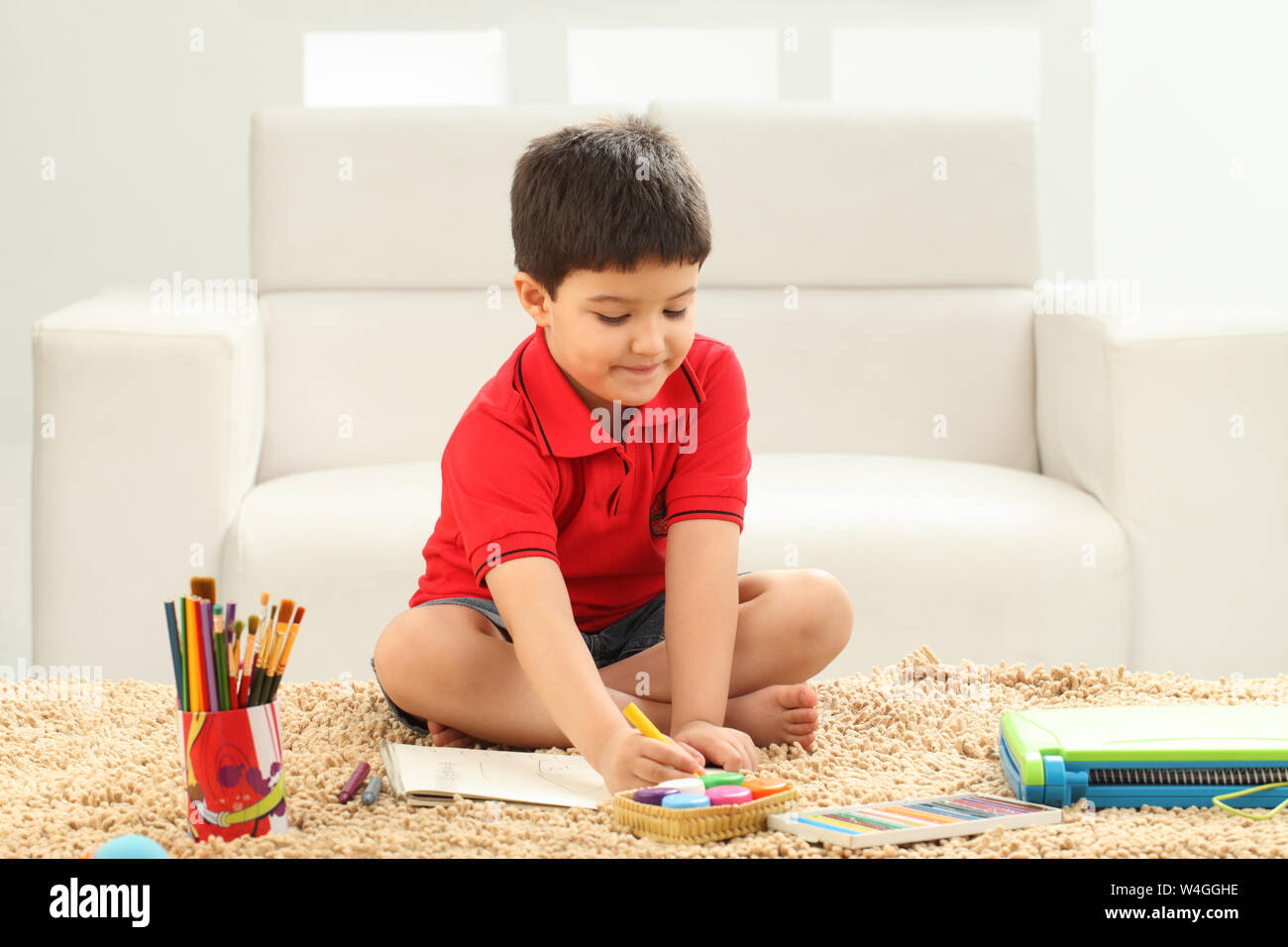 Boy coloring a book in a living room Stock Photo