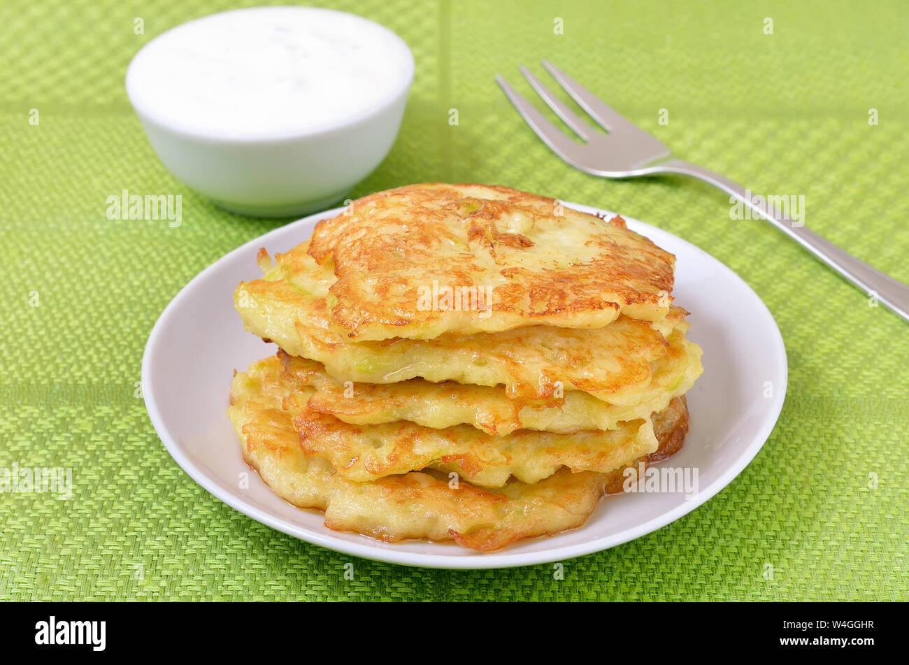 Fried courgette pancakes on white plate Stock Photo