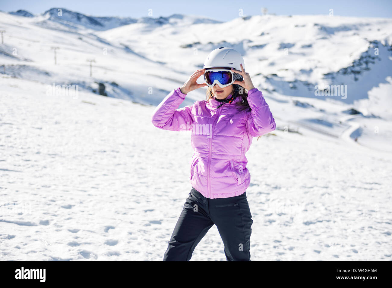 Woman wearing ski clothing getting ready to ski at the Sierra Nevada, Andalusia, Spain Stock Photo