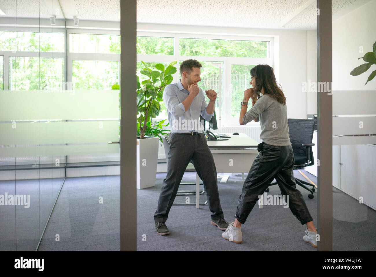 Businessman and businesswoman fighting in office Stock Photo