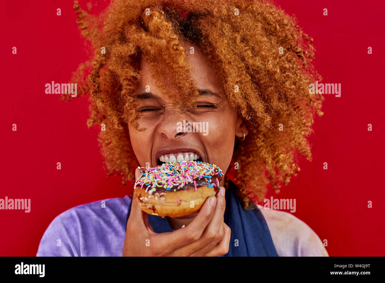 Portrait of woman eating a donut Stock Photo