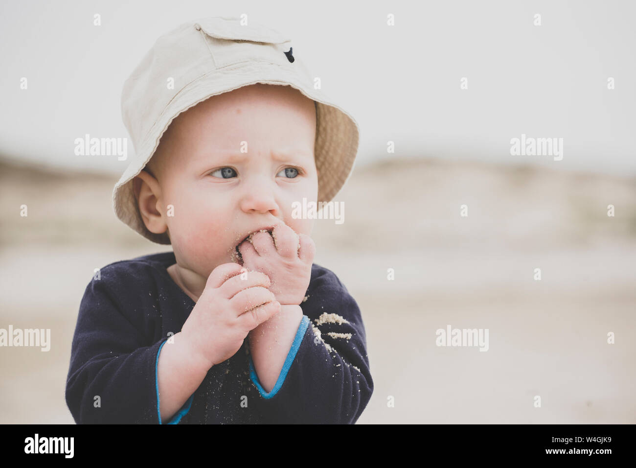 Baby boy eating sand on the beach Stock Photo Alamy