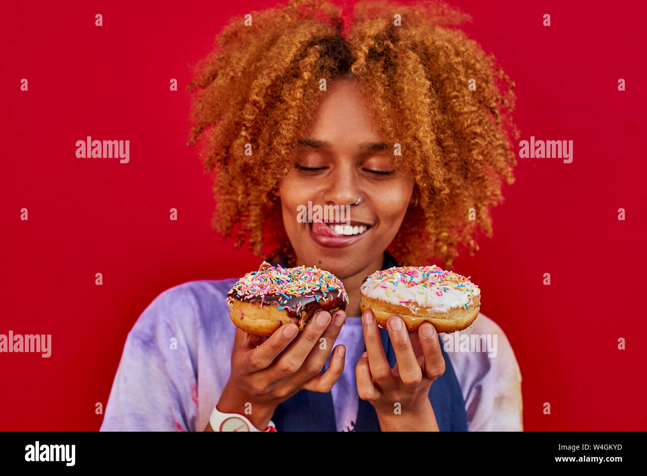 Woman choosing which donut to eat Stock Photo