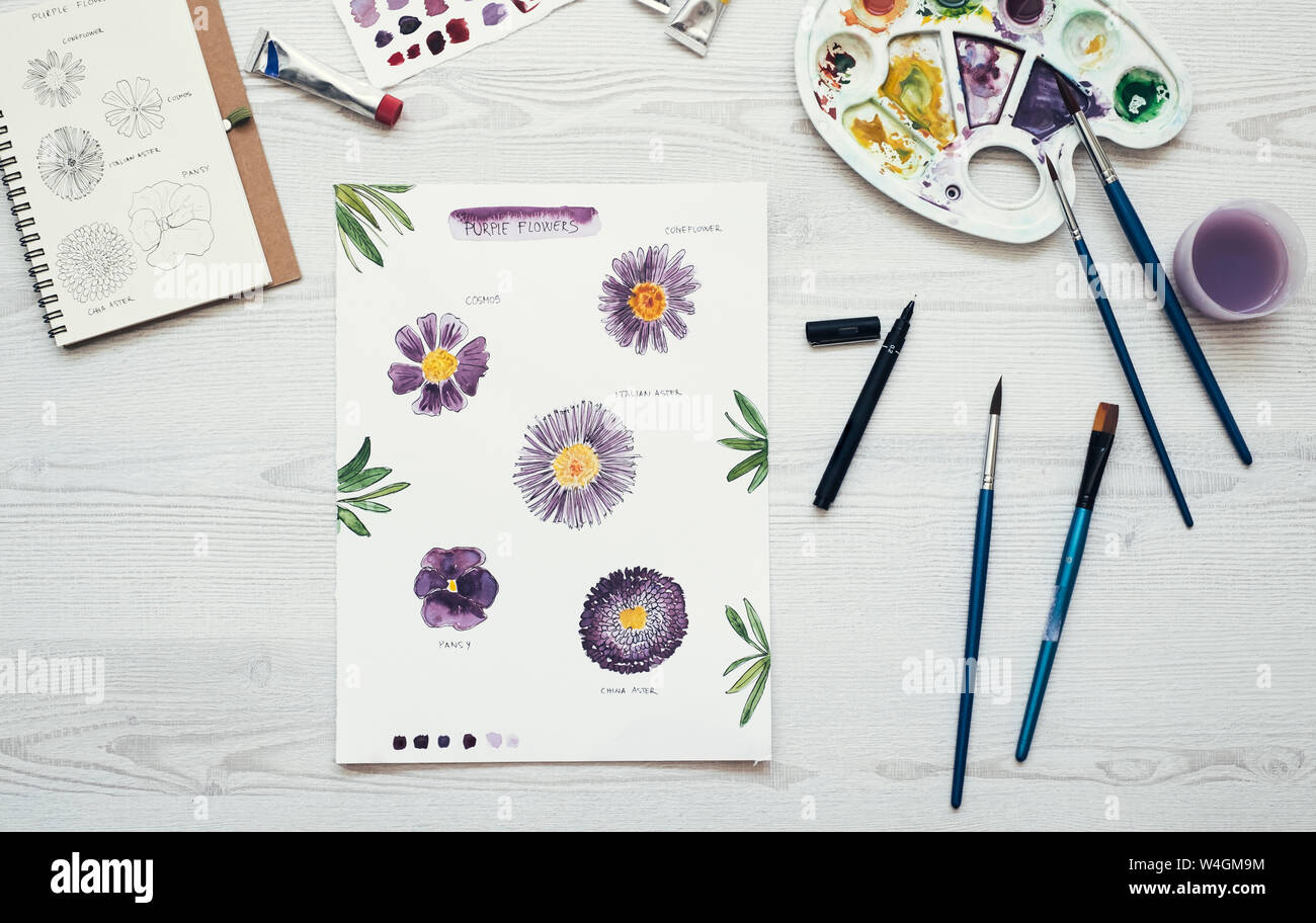 Watercolor painting of purple flowers on the desk, top view Stock Photo