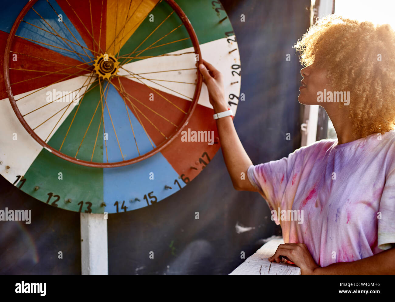 Woman turning wheel of fortune Stock Photo