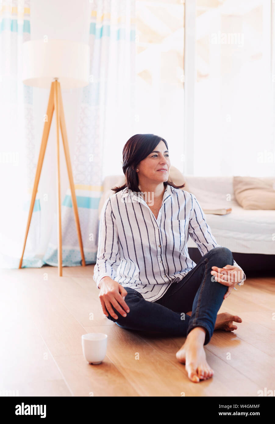 Mature woman sitting on floor at home hi-res stock photography and ...