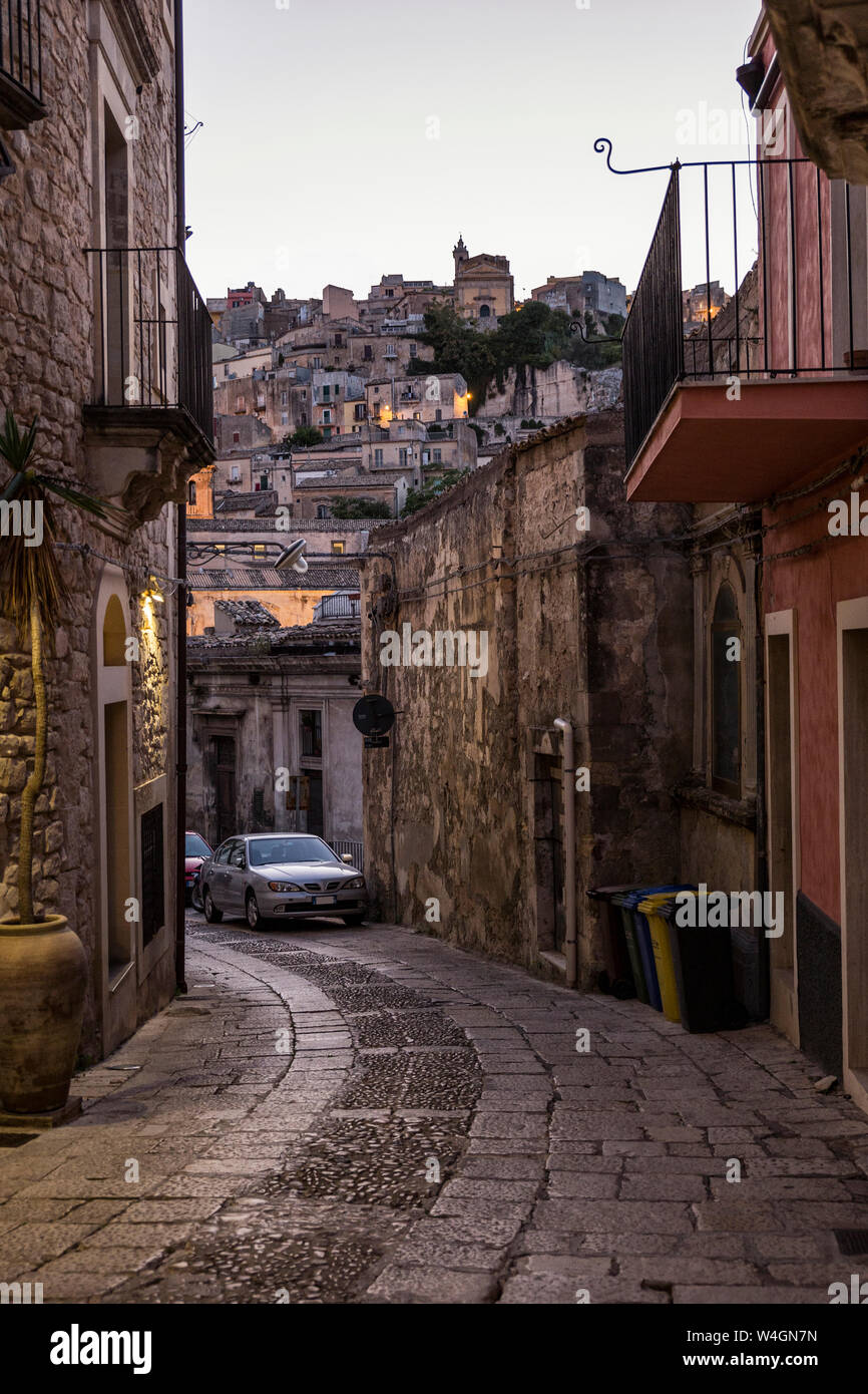 View from an alley in Ragusa Ibla to Ragusa Superiore at dusk, Ragusa, Sicily, Italy Stock Photo
