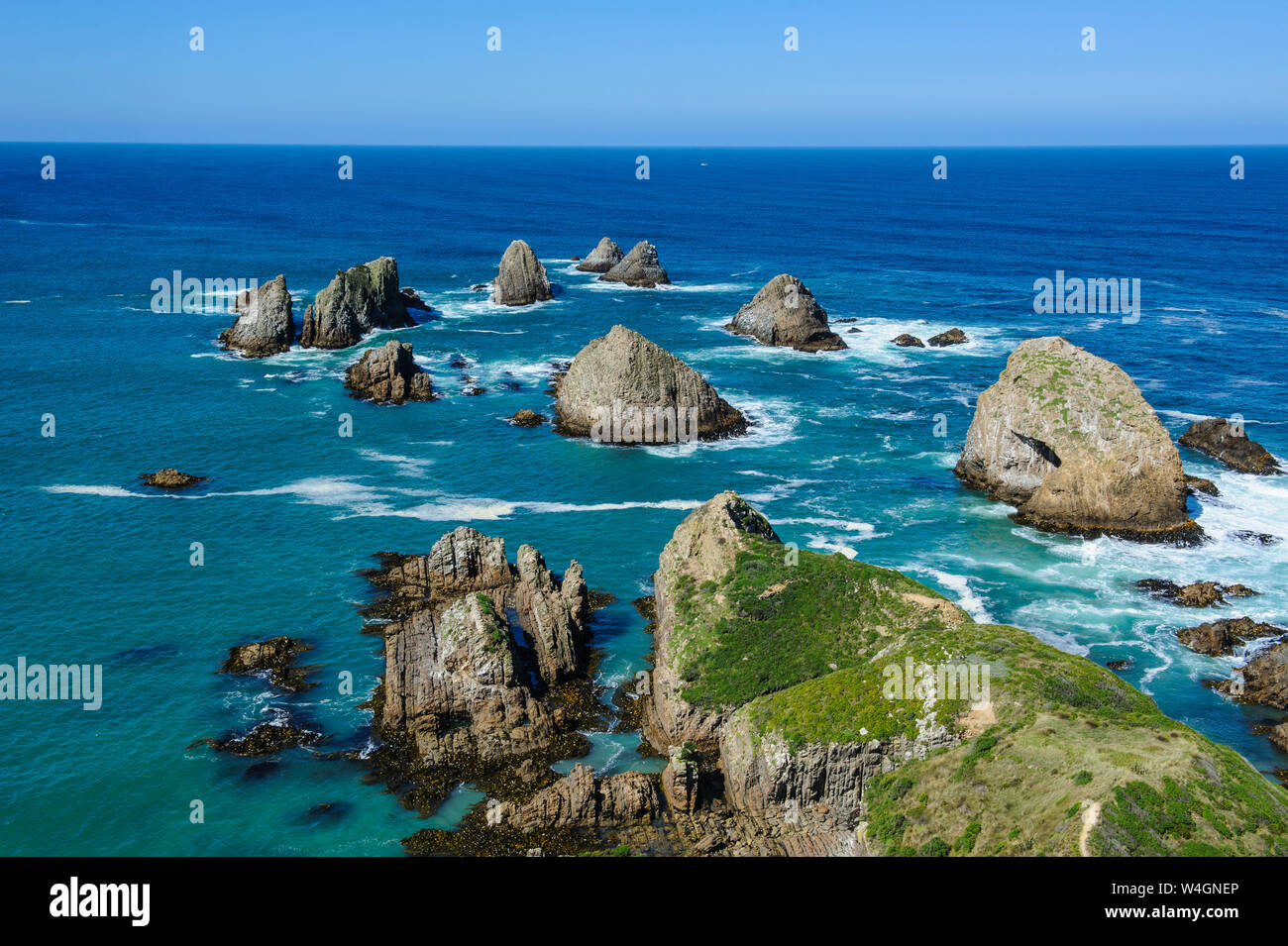 View from the Nugget Point Lighthouse in the turquoise waters with huge rocks, The Catlins, South Island, New Zealand Stock Photo