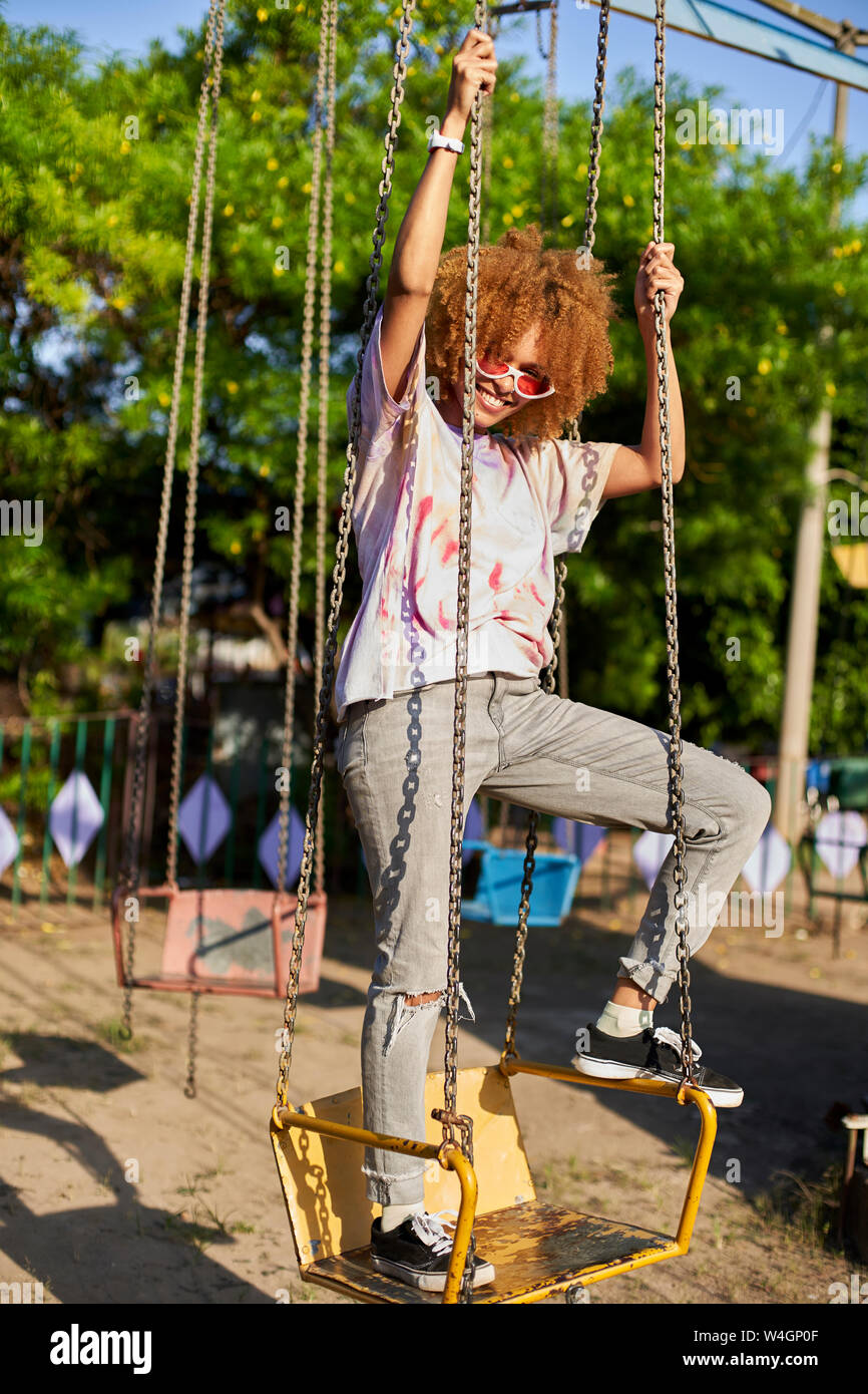 Portrait of happy woman on a swing Stock Photo