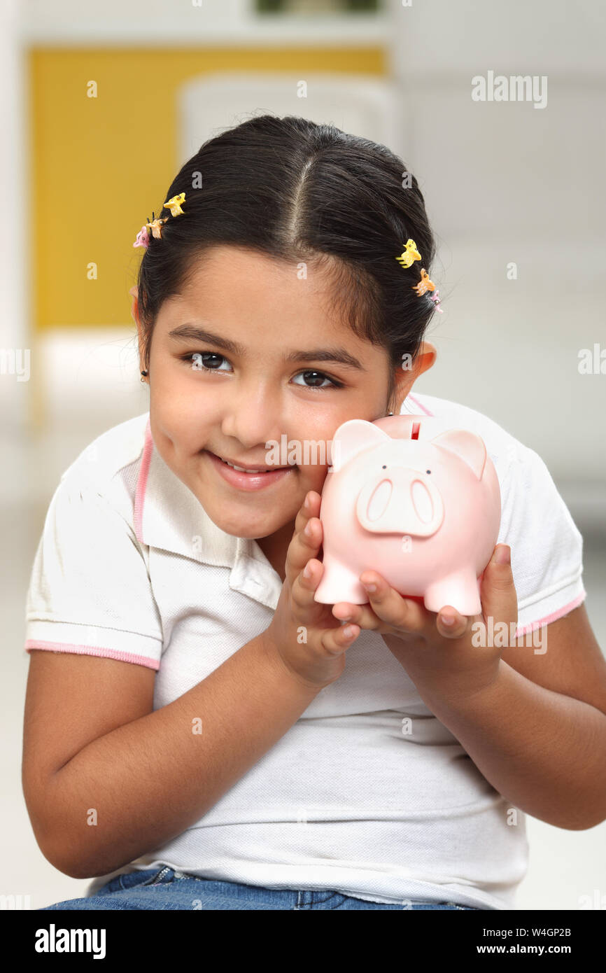 Indian girl holding piggy bank hi-res stock photography and images - Alamy