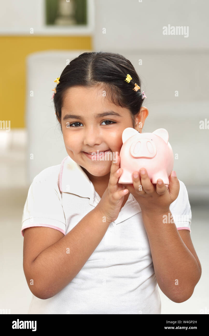 Girl showing a piggy bank and smiling Stock Photo Alamy