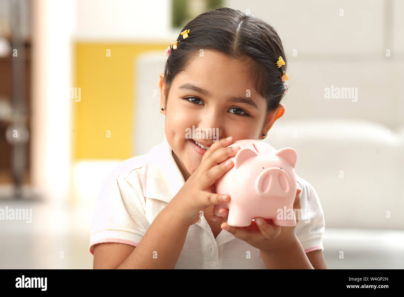 Indian girl holding piggy bank hi-res stock photography and images - Alamy