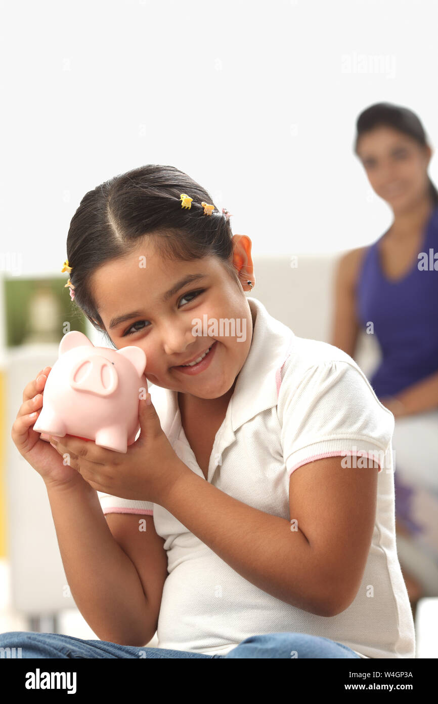 Indian girl holding piggy bank hi-res stock photography and images - Alamy