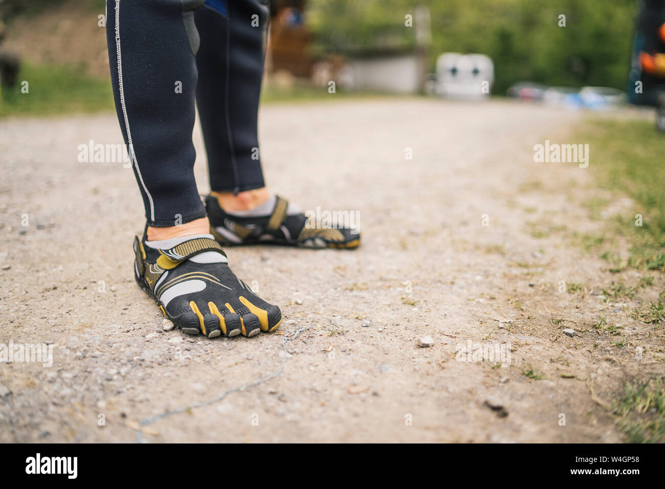 Close-up of man wearing wetsuit and galoshes standing on a path Stock Photo