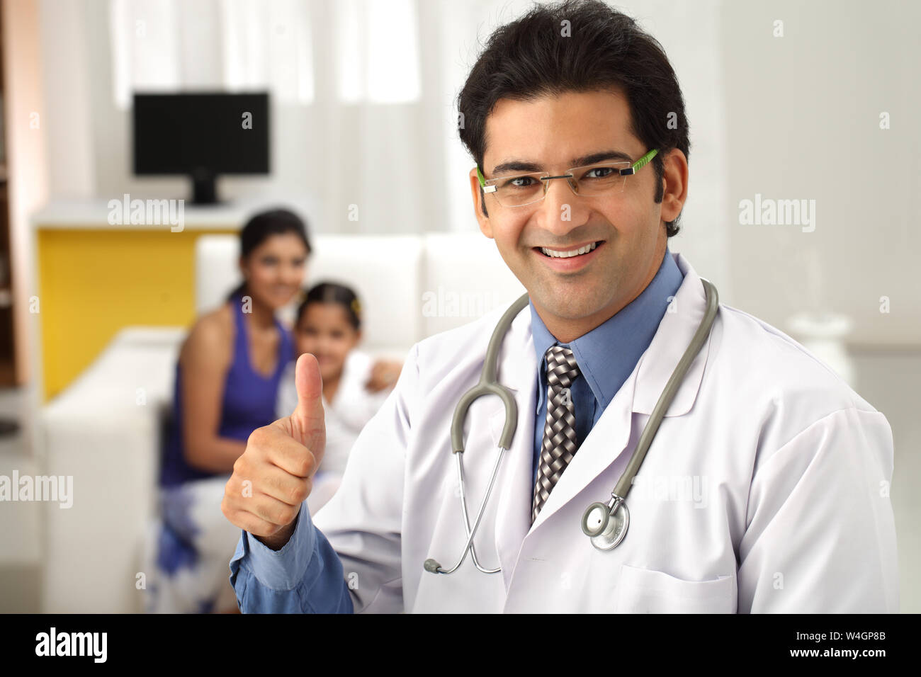 Male doctor showing thumbs up sign and smiling Stock Photo - Alamy